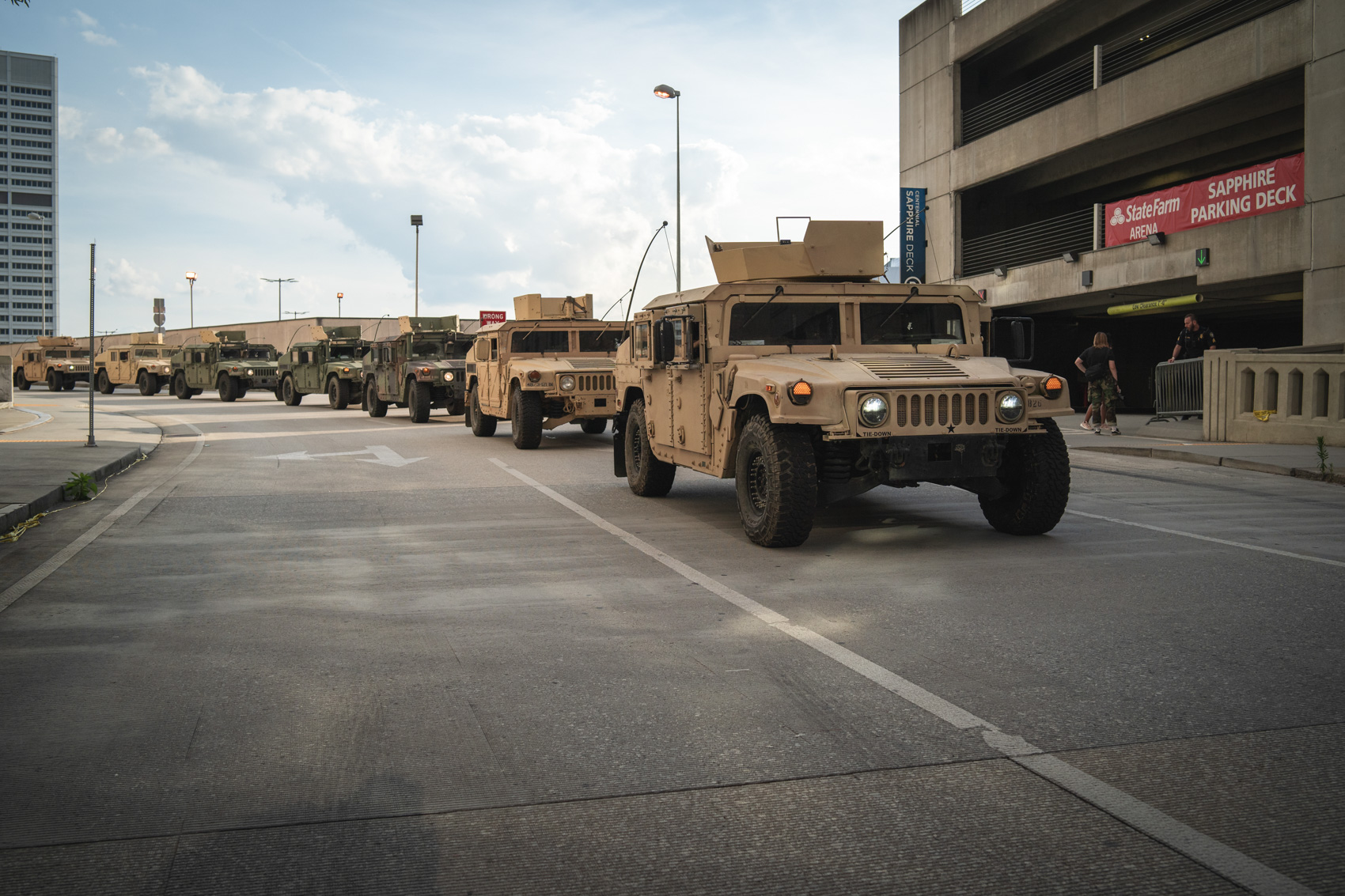 a line of Humvees traveling through dowtown