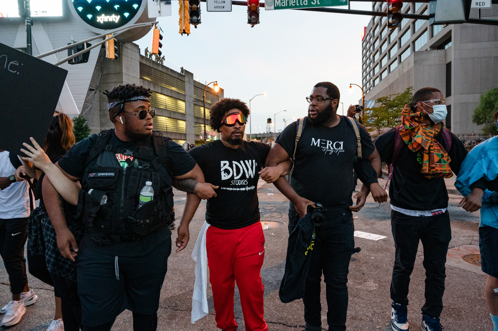 four male protestors linking arms