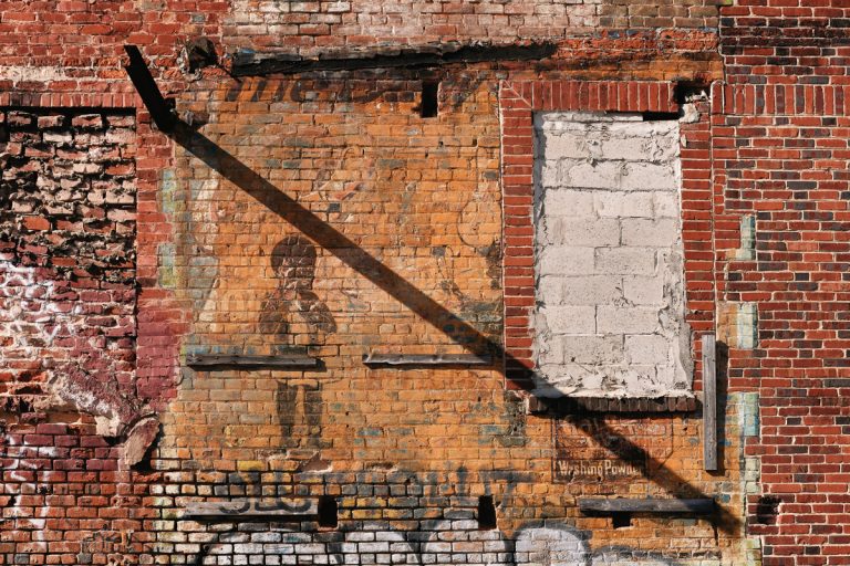 A faded 20th-century advertisement, revealed after a tornado, is a visual reminder of Atlanta’s complicated past