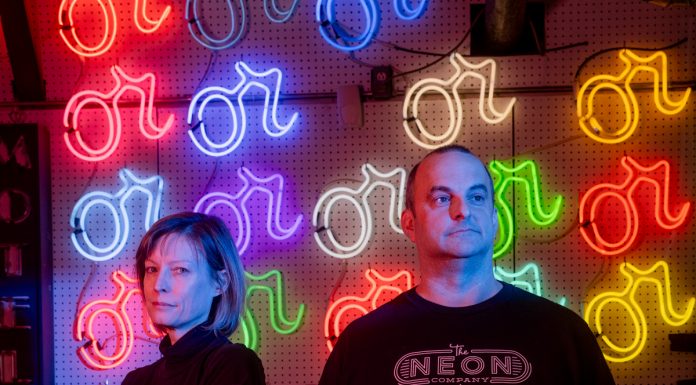 Atlanta’s The Neon Company, one of few surviving fabricators of neon signs in the U.S., is still going strong Vyvyan Hughes and Craig Weido in front of a wall of neon signs