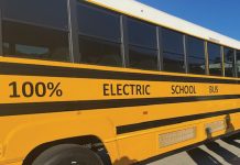 Atlanta Public Schools buses are doing the electric slide A yellow school bus that says "100% electric school bus" on the side