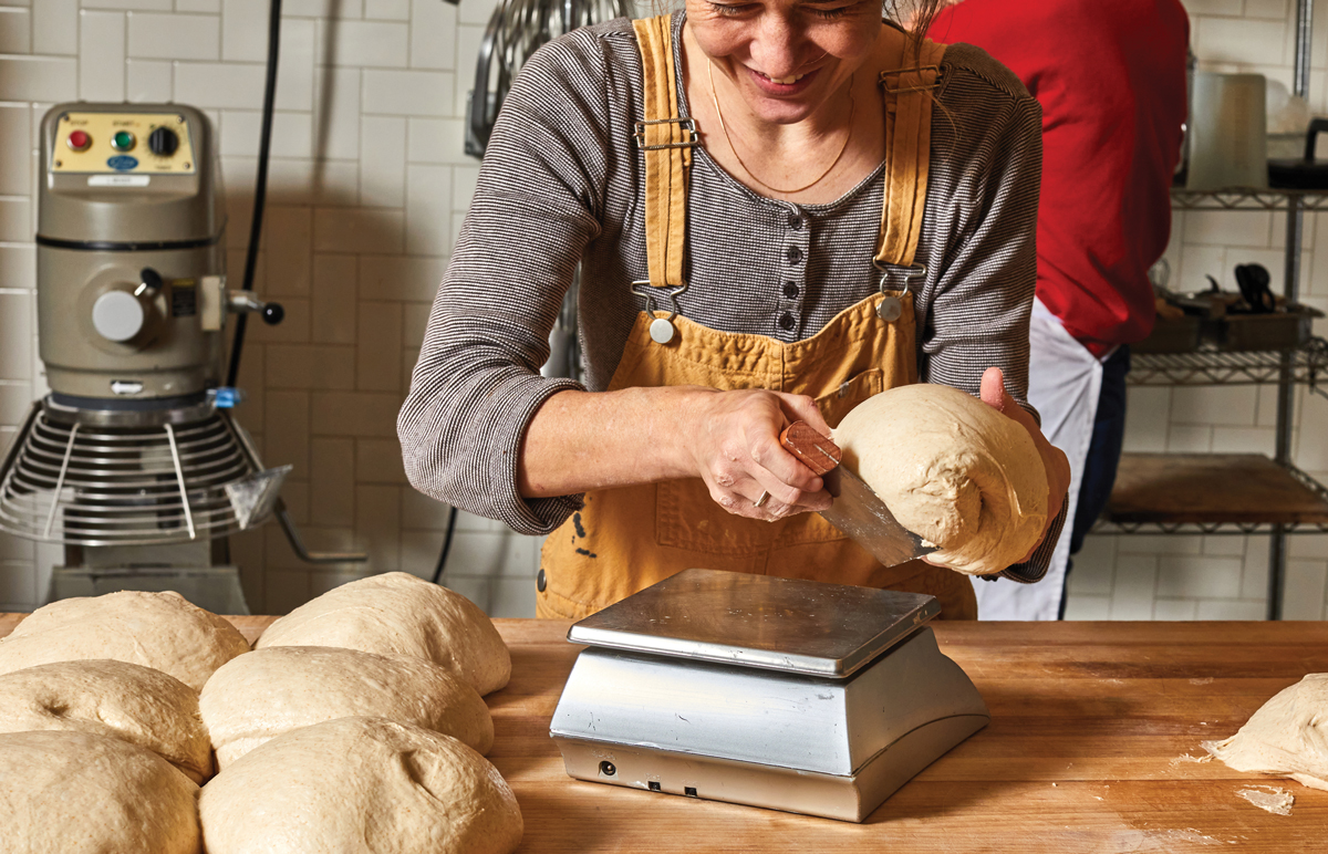Sarah Dodge cuts from a bulk ferment to make a 1,000-gram loaf.