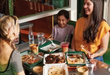These 6 Atlanta restaurants feed families on a budget Friends laughing while sitting at a table with multiple trays of food and drinks