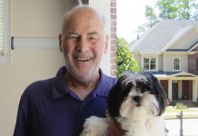 50 years of dog training wisdom from Atlanta’s original dog whisperer Michael Quattrochi smiles, holding a fluffy dog in his left arm