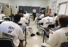 a classroom of inmates sit and listen