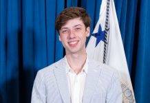 Parker Short smiling while wearing a blue pinstripe suit