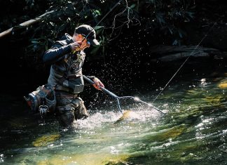 3 outdoor wonderlands for Georgia adventure-seekers a man catches a trout in North Georgia's stream