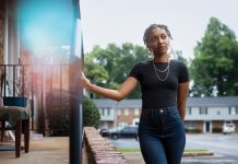 Tatiana stands by a townhouse's railings