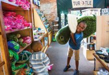 two kids smile while giant plushie turtles at the gift shop