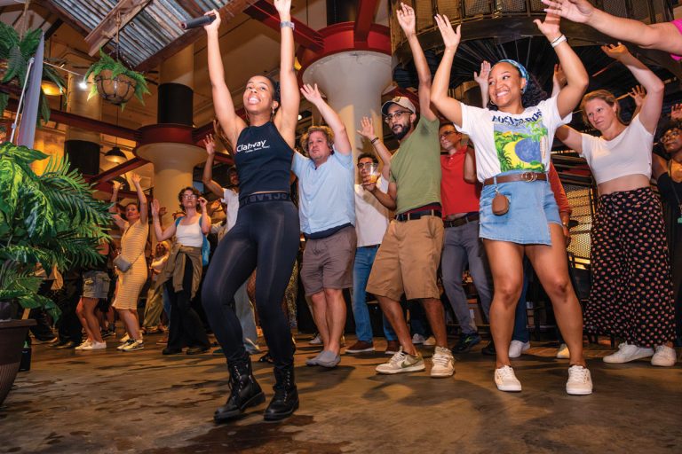 a group of people dancing with their arms up in the air at Ponce City Market