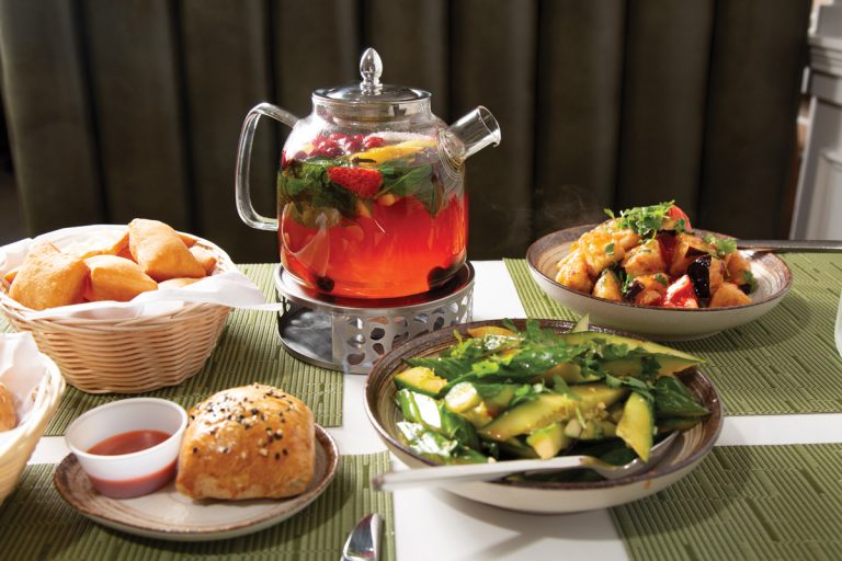 an array of dishes and a jug of fruit tea at Laghman Express