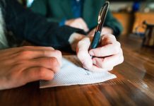 Editor’s Journal: The grace of creativity A man in a coffee shop writing on a napkin with a pen