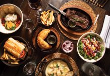a spread of authentic argentine food including steak, empanadas, fries, and wine
