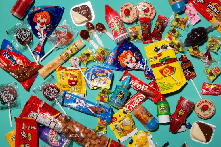 Dozens of colorful Mexican candies spread out on a blue backdrop