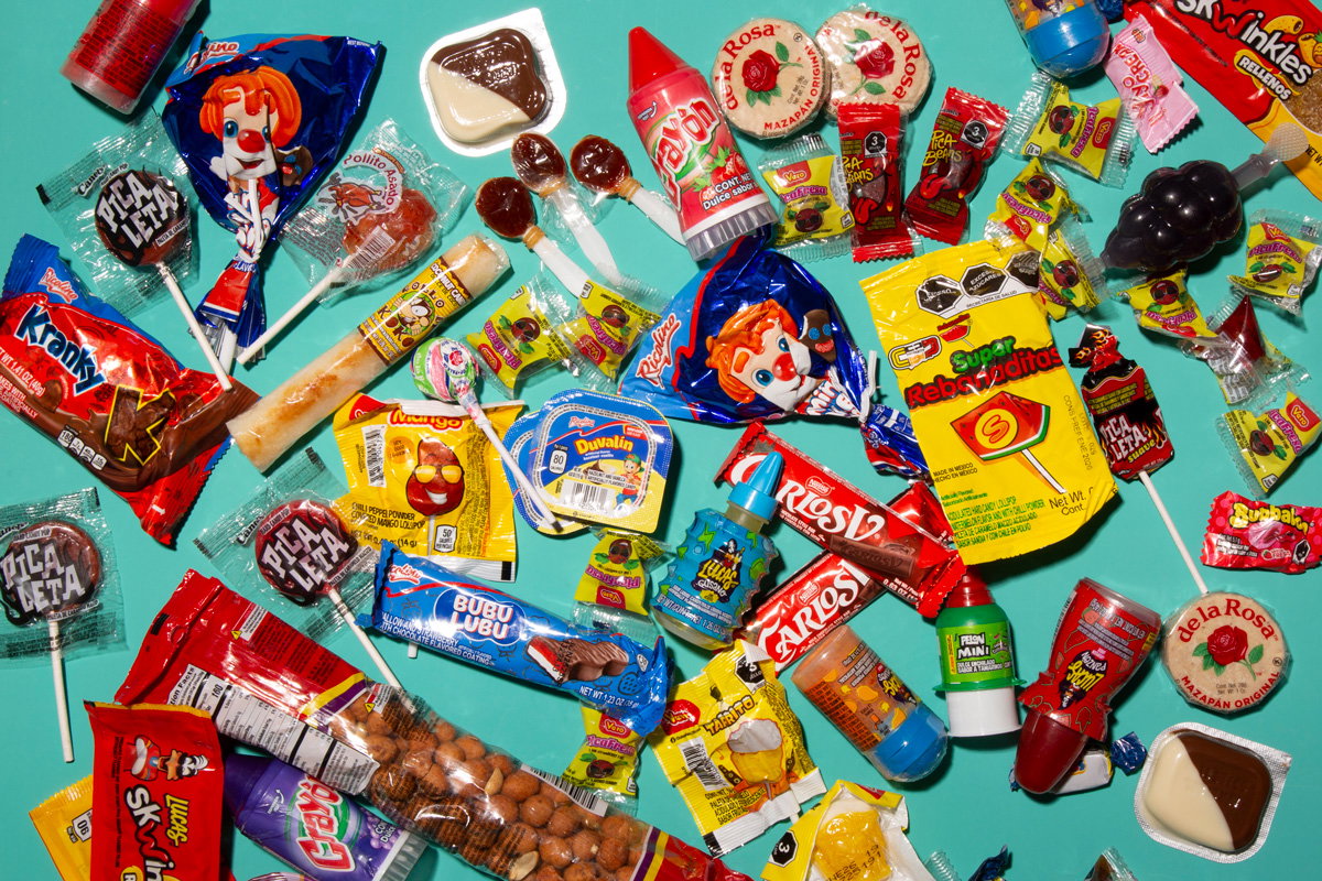 Dozens of colorful Mexican candies spread out on a blue backdrop