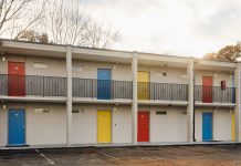 The Ralph David House offers affordable housing and support for previously unhoused Atlantans the exterior facade of the apartments, including bright yellow, red, and blue doors