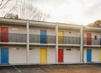 The Ralph David House offers affordable housing and support for previously unhoused Atlantans the exterior facade of the apartments, including bright yellow, red, and blue doors