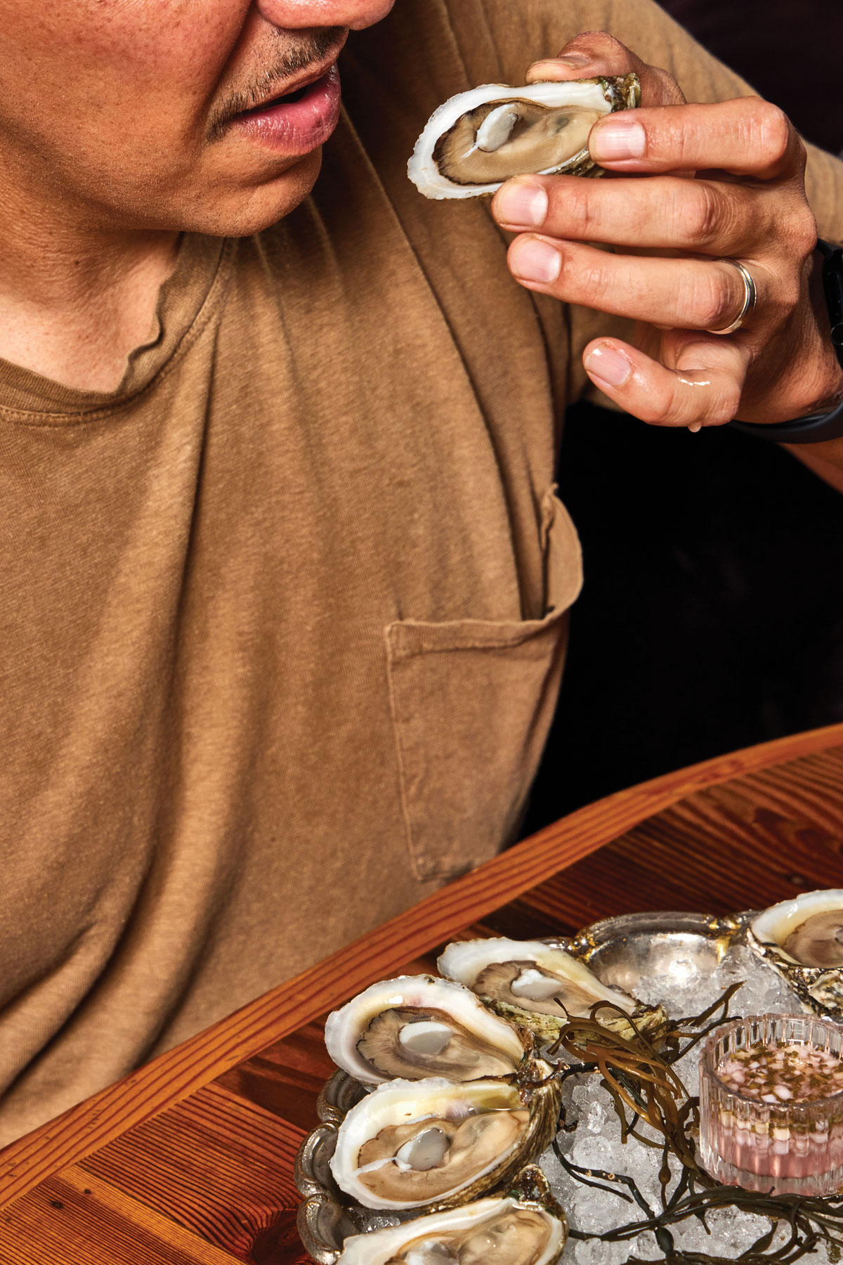 A man brings shiny dimes (oysters) to his mouth
