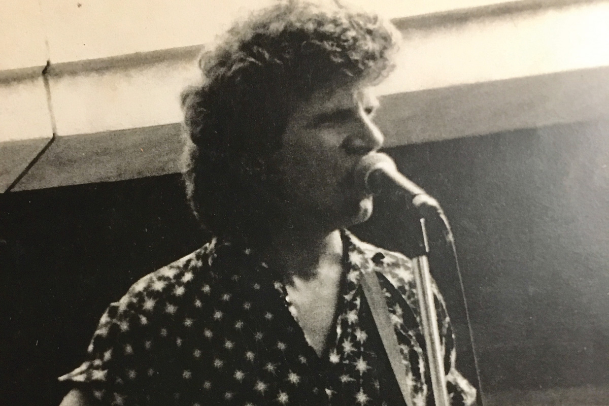 a black and white photo of a young Harrison singing into a mic