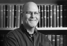 Editor’s Journal: Announcing my retirement from Atlanta magazine A black and white headshot of Scott Freeman crossing his arms and smiling in front of a bookshelf