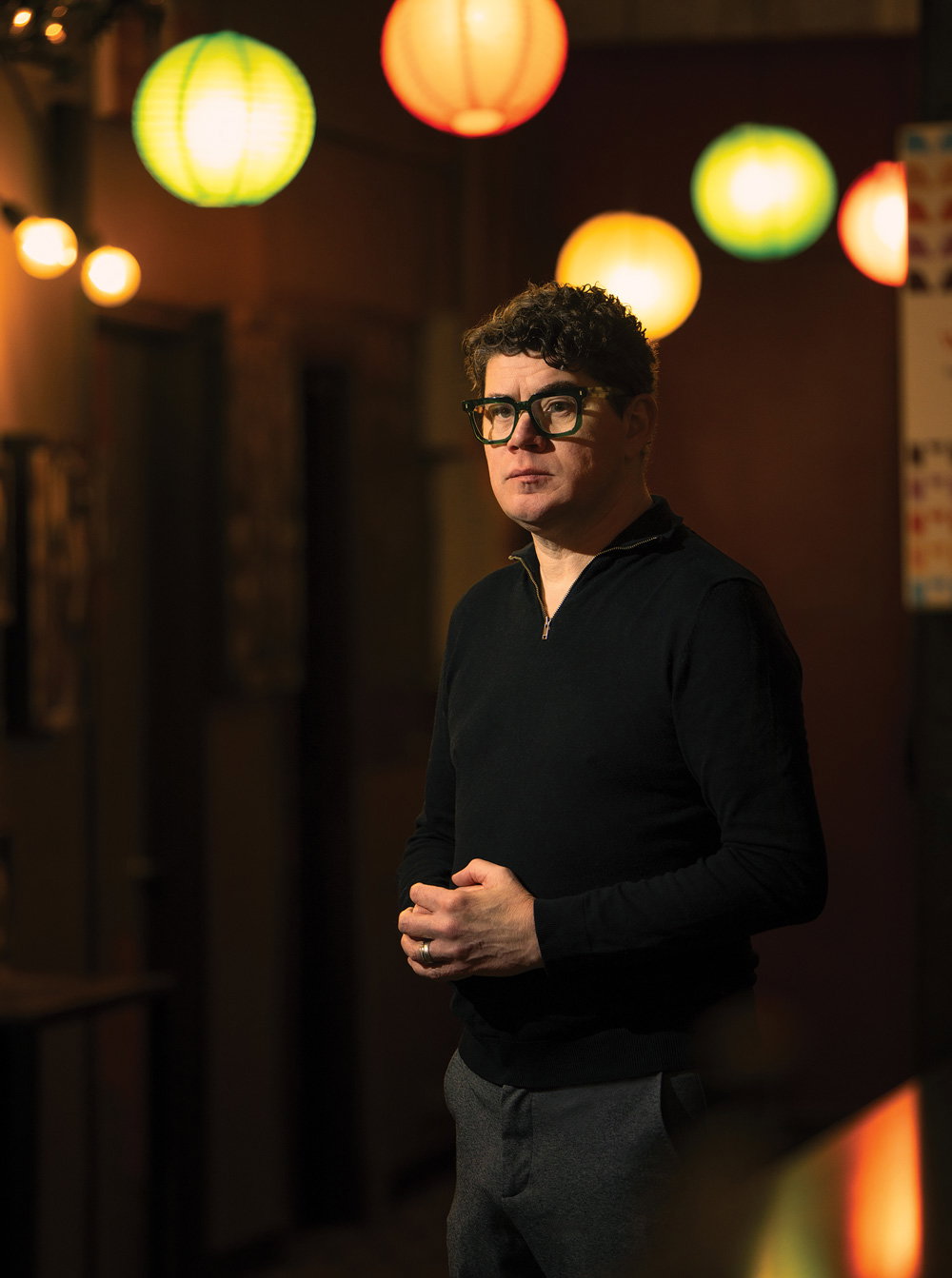 Chip Powell stands below colorful paper lanterns