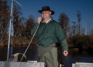A swamp storyteller shares insider tips for the Okefenokee Richard Rhodes, speaks into a microphone on the boat