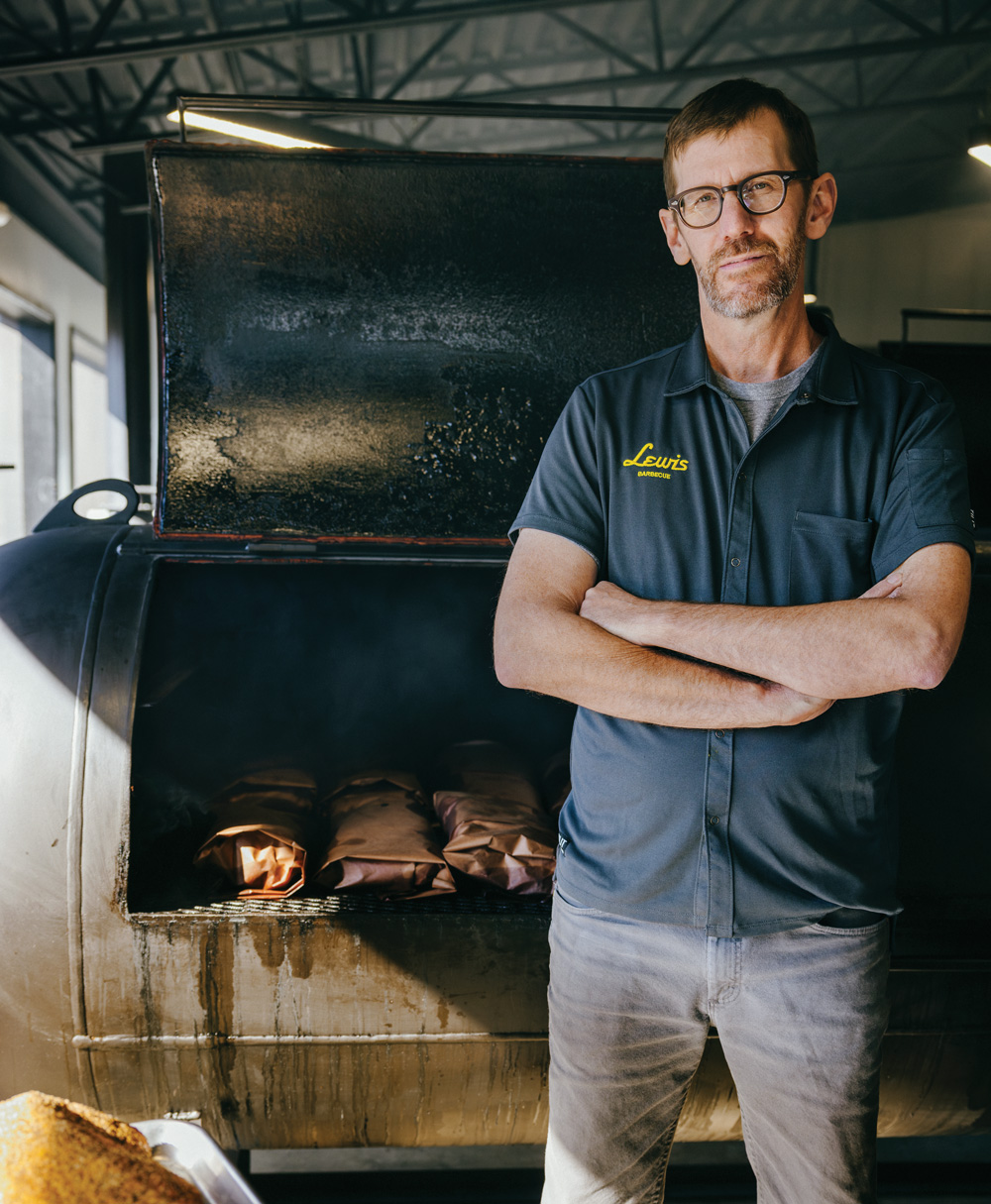 John Lewis stands by one of his custom-built smokers at the Atlanta outpost of Lewis Barbecue