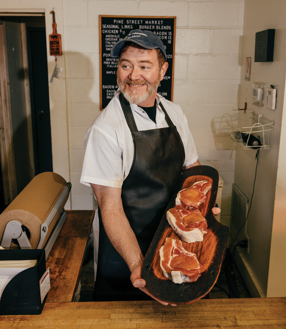 Pine Street Market owner/butcher Rusty Bowers shows off herb-brined pork chops at his Avondale Estates shop.