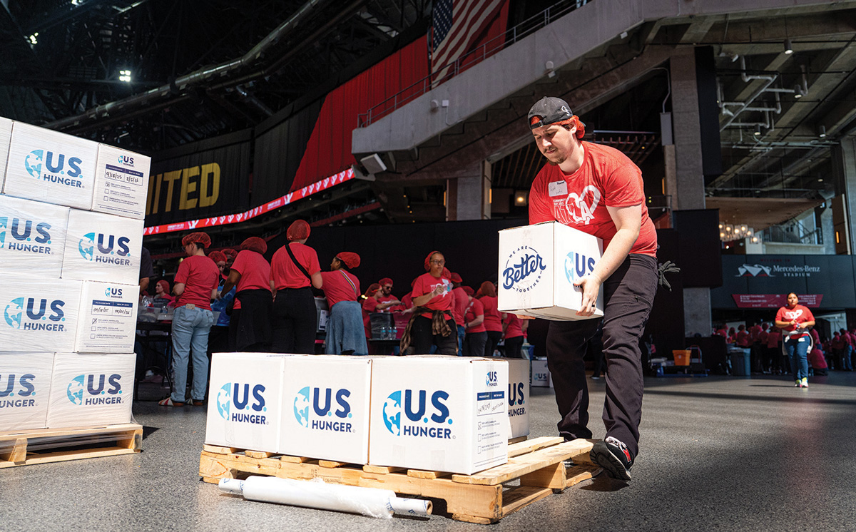 volunteers stack boxes of food at the stadium
