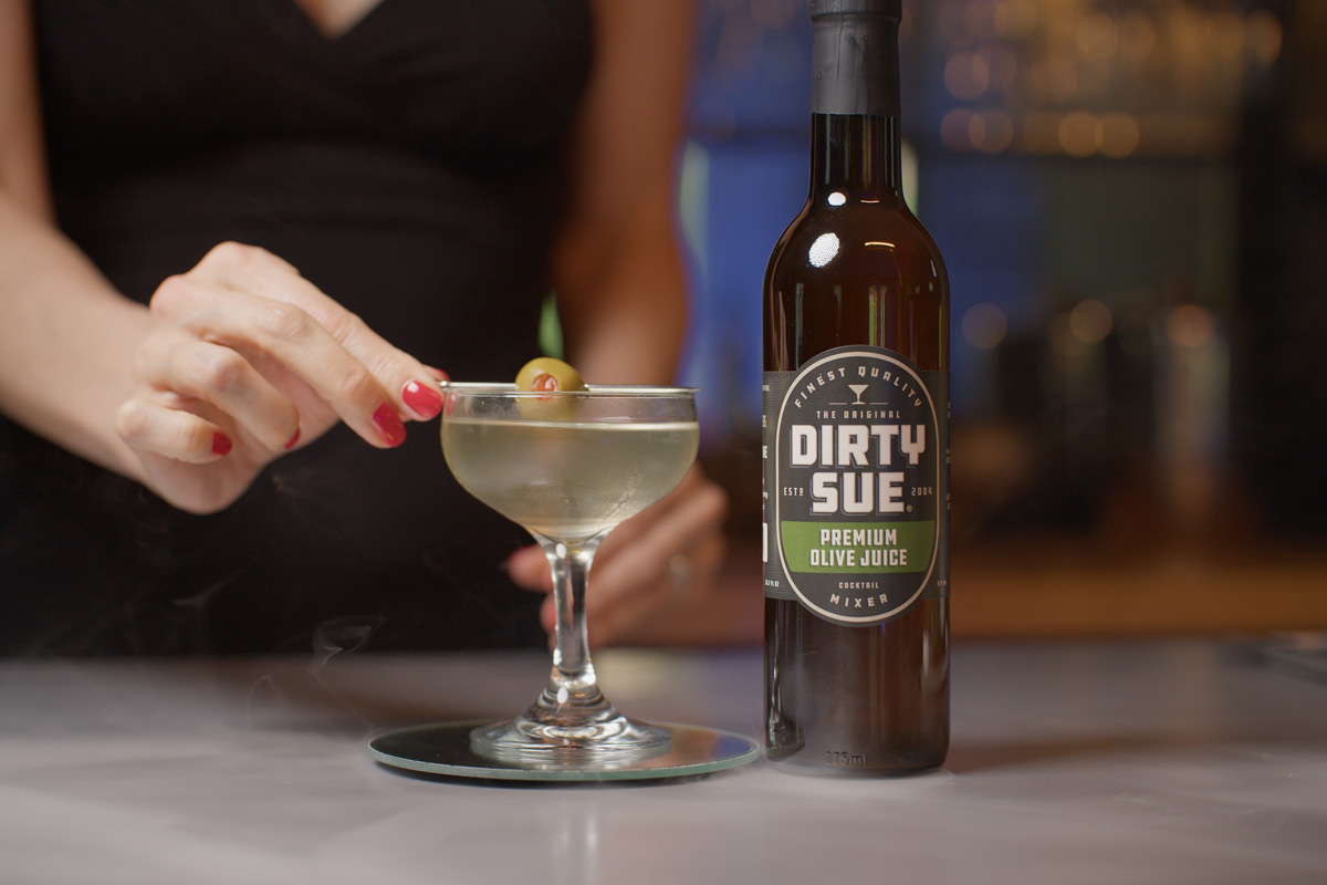 reaching for a glass in an olive juice ad
