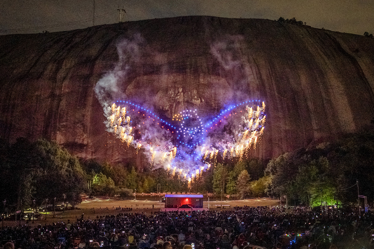 a drone show displays the shape of an eagle in front of a crowd of people at Stone Mountain Park