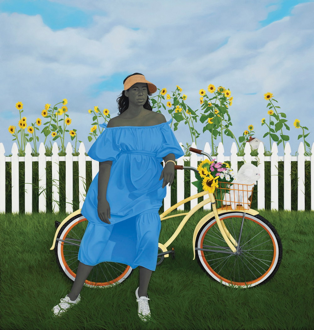 a woman in a blue dress stands by her bike with a white dog in the basket and a white picket fence in the background