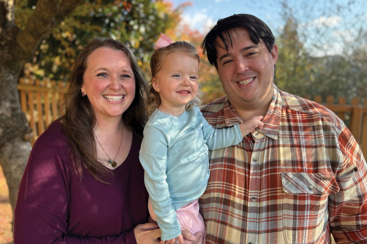 Maeve Ross (middle), three years old and thriving, with her parents