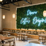 6 coffeehouses fueling Atlanta’s newfound love for Yemeni coffee A wall of plants with a neon sign reads "Discover Coffee's Origin!"