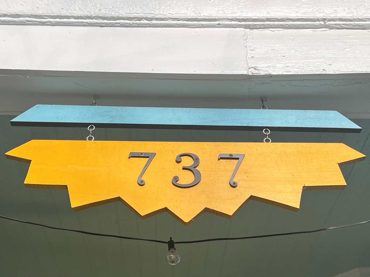 a yellow sign with spikes like the shape of the sun reads the numbers 737