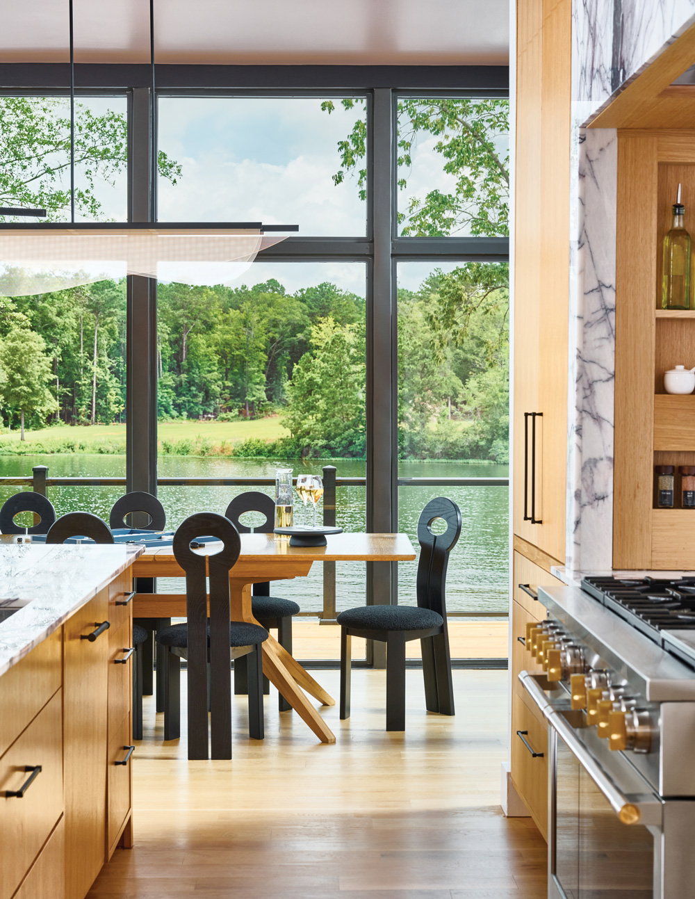 a warm and inviting space with floor to ceiling windows with a view of the lake