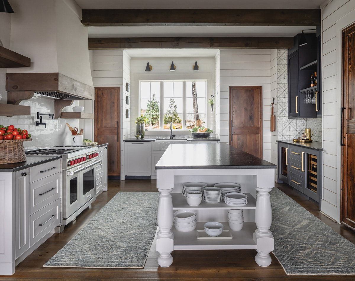 a grey and white kitchen with running rugs and wooden doors 