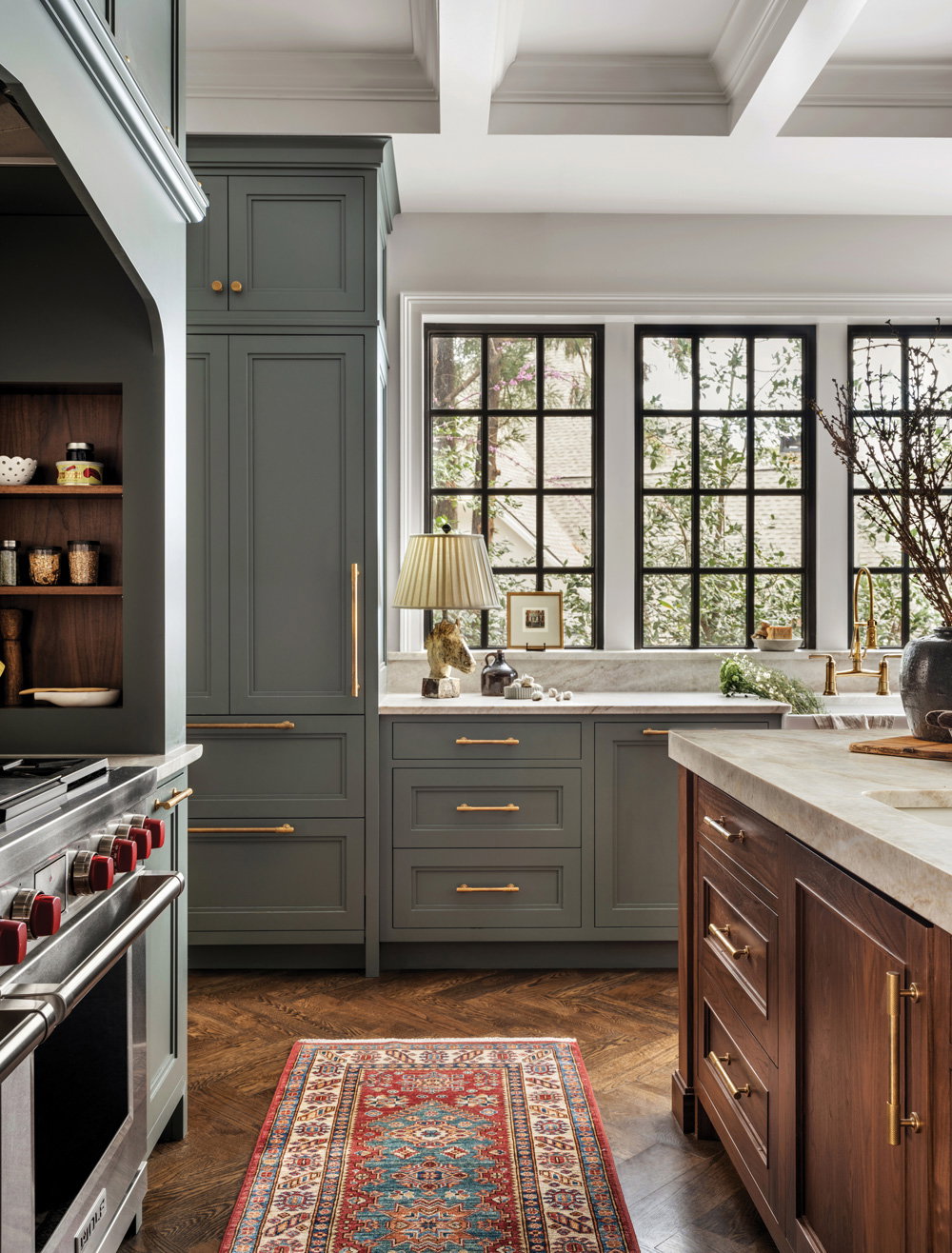 a rustic kitchen with wooden and shelving, bright windos, and a red runner rug