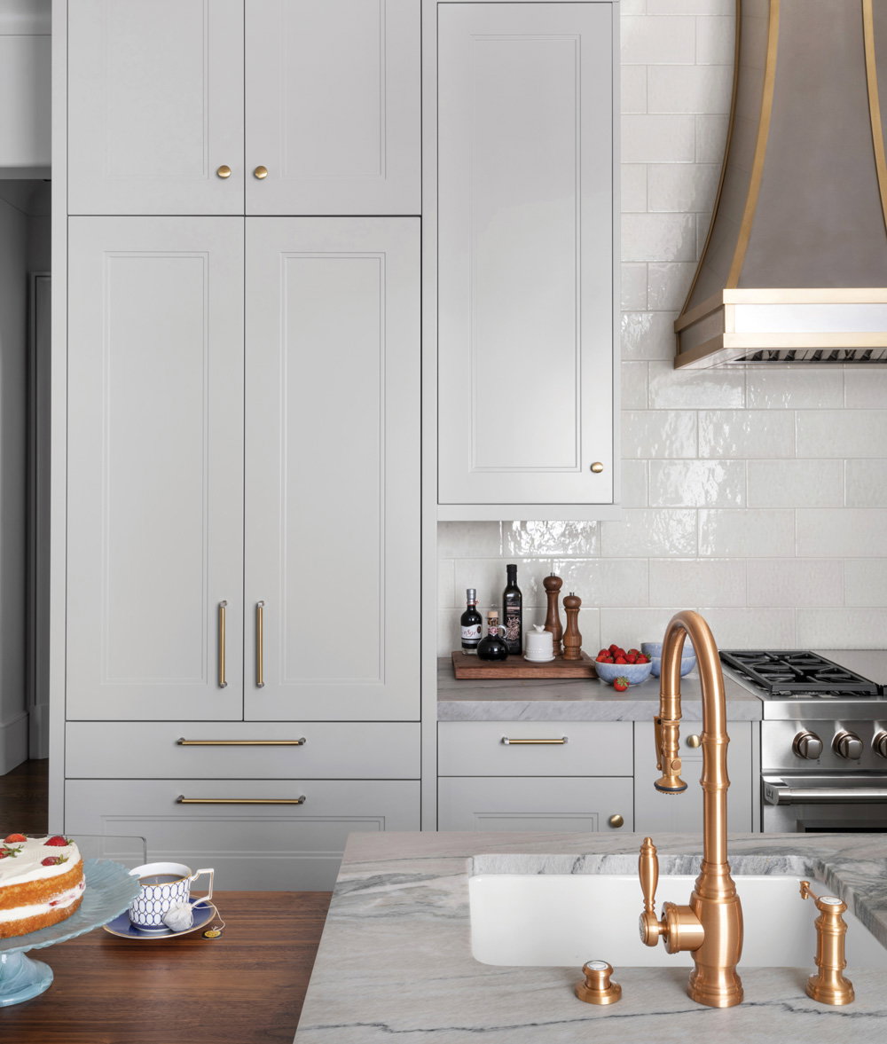a white kitchen with yellow gold faucets and cabinet handles