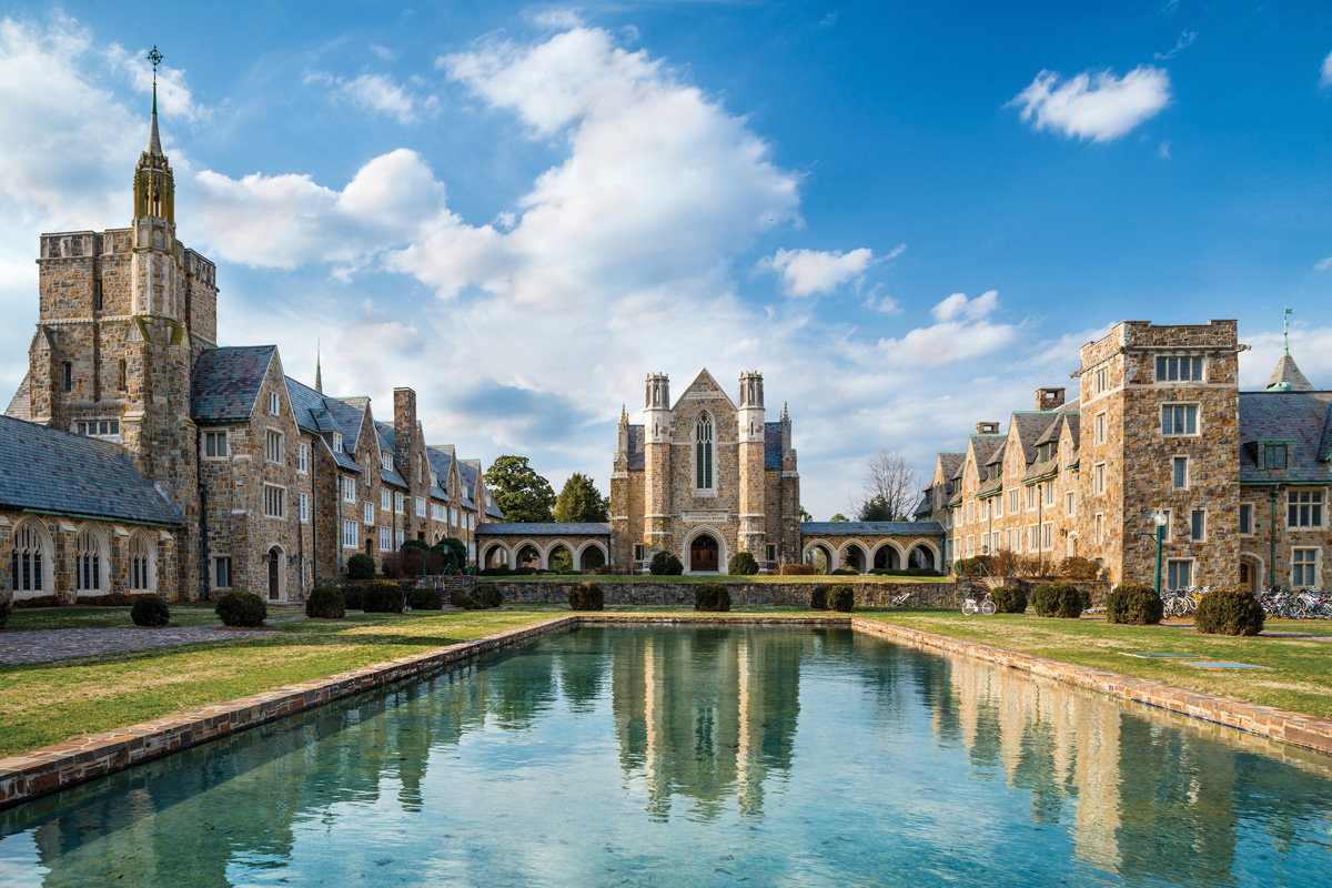the cobblestone buildings of Berry College in front of their clear blue pond