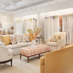 the inside of the cream and beige colored showroom with accent yellow chairs and an array of wallpapers to look through