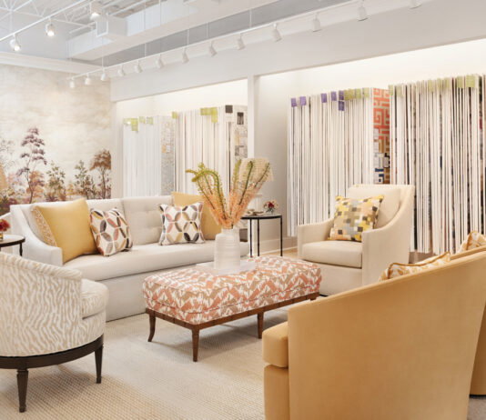 the inside of the cream and beige colored showroom with accent yellow chairs and an array of wallpapers to look through