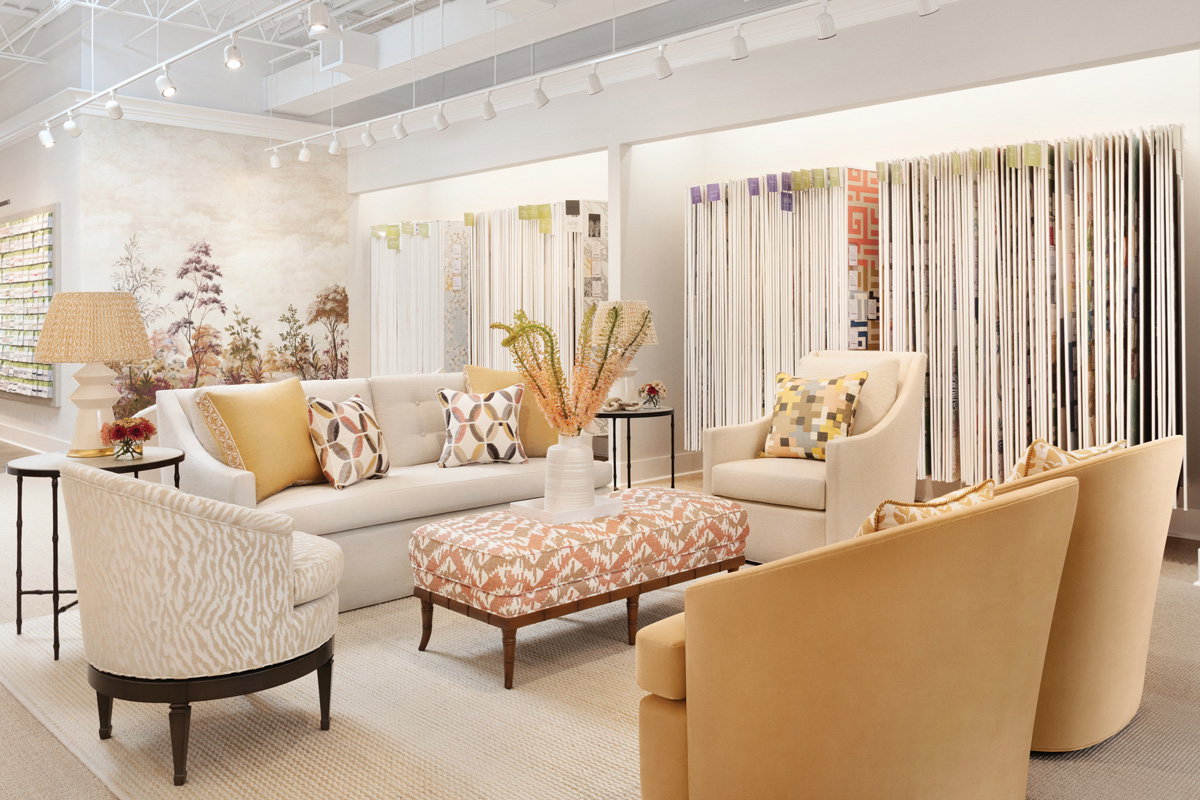 the inside of the cream and beige colored showroom with accent yellow chairs and an array of wallpapers to look through