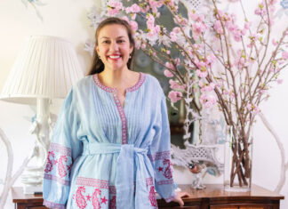 Atlanta thrifting expert Elizabeth Cook shares her best advice on secondhand shopping Elizabeth Cook stands in front of a woden console table with bright light pink cherry blossom flowers atop it.