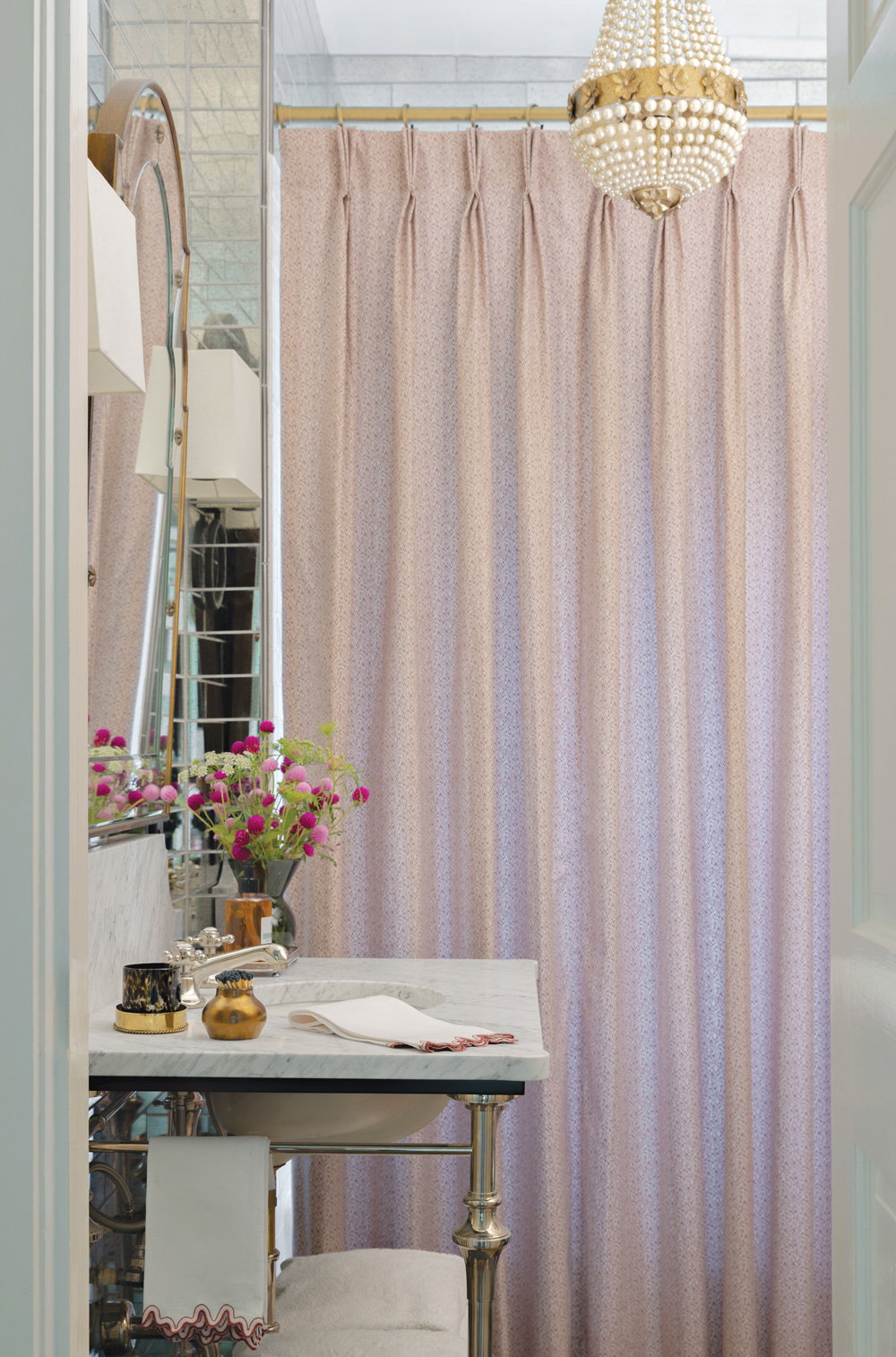In the guest bath a pleated shower curtain and an upgraded pedestal vanity with a custom marble top