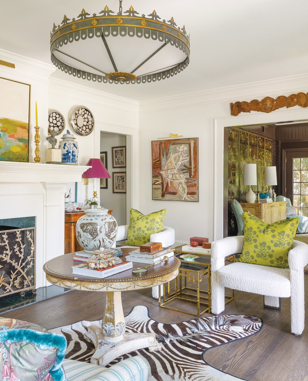 The house's living room with thick baseboards, crown molding, and an ornate fireplace