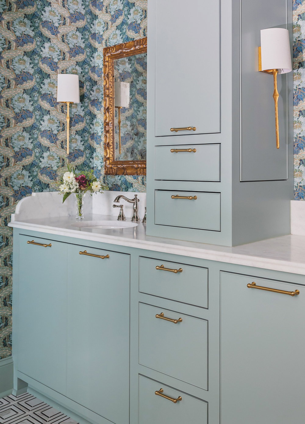 light blue cabinets with brass accents and a patterned blue wallpaper
