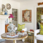 The house's living room with thick baseboards, crown molding, and an ornate fireplace
