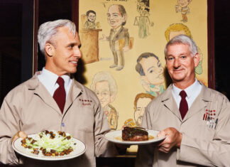 Atlanta’s 10 Best Steakhouses: Bones A server, Aaron, and John Wenger smile and hold plates of food