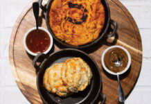 biscuts, gravy, and an array of other dishes over a white brick table